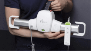 Close-up of a caregiver holding a white Amico GoLift portable ceiling lift motor with hand control and carry strap.