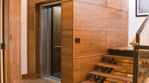A homeowner reviewing an insurance policy document beside a residential home elevator, representing coverage questions after a home lift installation