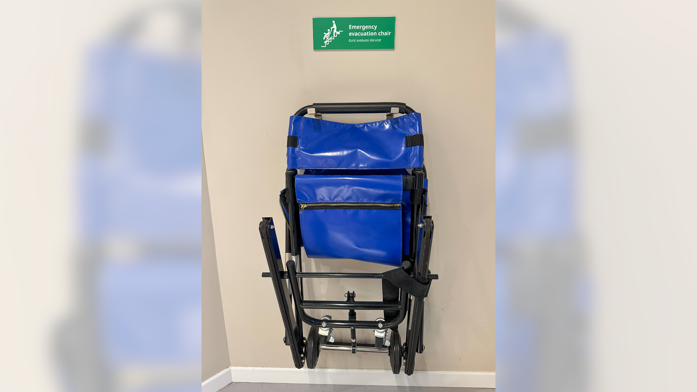 An evacuation chair stored near a stairwell in a commercial building as part of an ADA-compliant emergency egress plan