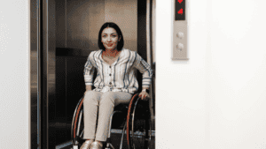 A wheelchair user riding inside a spacious Elvoron home elevator cab sized for a wheelchair and caregiver in a North Texas home